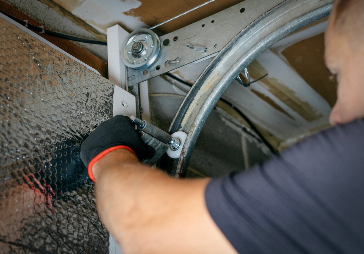 Handwerker montiert und prüft ein Garagentor